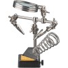 Kolmas käsi suurennuslasilla ja juotinjalustalla